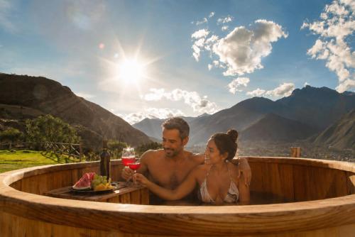 a man and a woman sitting in a wooden tub at Tara Vegan Lodge - Sacred Valley in Urubamba