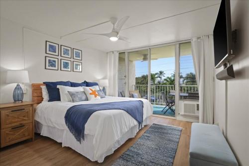 a bedroom with a large bed and a balcony at Puako Beach Condo 210 - 3 Bedrooms in Waikoloa
