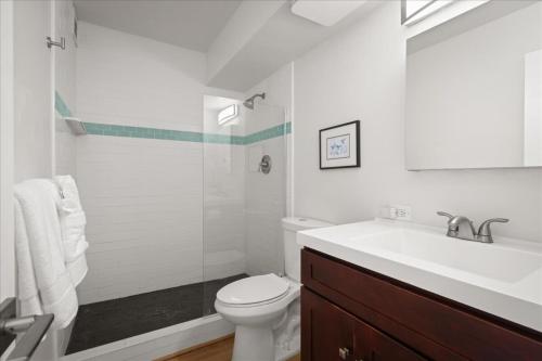 a white bathroom with a sink and a toilet at Puako Beach Condo 210 - 3 Bedrooms in Waikoloa