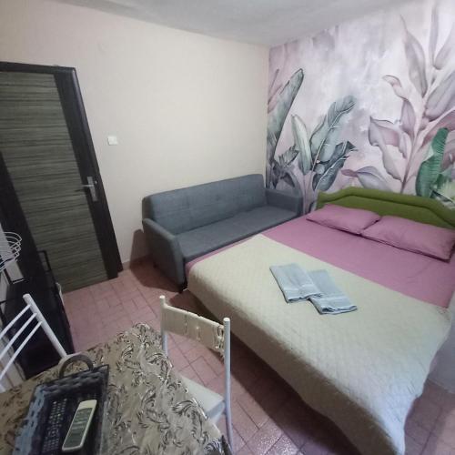 a bedroom with a bed and a couch in a room at Sky 2 Petrovac in Babalonija