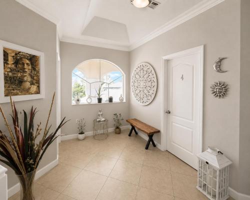 a hallway with a wooden bench and a window at The Garden, Miami Lakes in Miami Lakes