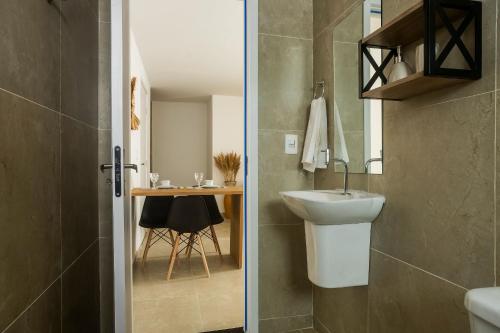a bathroom with a sink and a toilet and a table at Apartamentos mobiliados em Caruaru in Caruaru