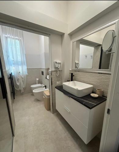 a bathroom with a sink and a toilet and a mirror at Chloè Vacanze in Iesi