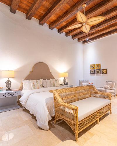 a bedroom with a large bed and a ceiling fan at Hotel Capellán de Getsemaní in Cartagena de Indias