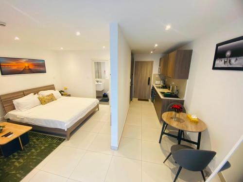 a bedroom with a bed and a kitchen with a table at Executive Studio at Bantree in Accra
