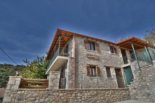 a large brick building with a large window at Gartagani Guest House in Stemnitsa
