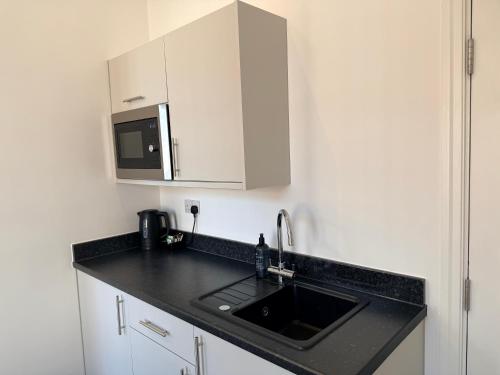 a kitchen with a sink and a microwave at Fishergate Residences in Preston