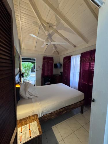a bedroom with a large bed with a ceiling at 1Fusion2 in Negril