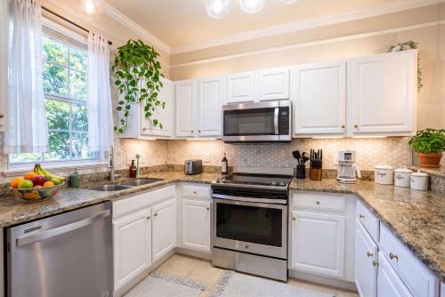 a kitchen with white cabinets and a microwave at Stylish Sanctuary King Beds Upscale Condo in Gainesville