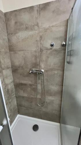 a shower with a glass door in a bathroom at Fogadó a Kóbor Macskához in Kőszeg