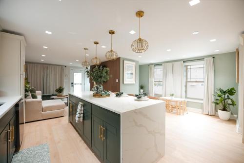 a kitchen with green cabinets and a living room at Coastal Sands Inn in Wildwood