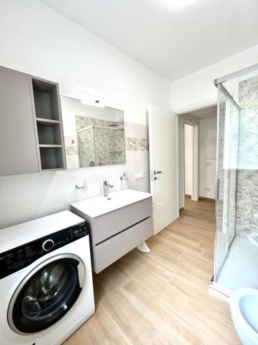 a washing machine in a bathroom with a sink at Panoramic and view apartments in Lezzeno