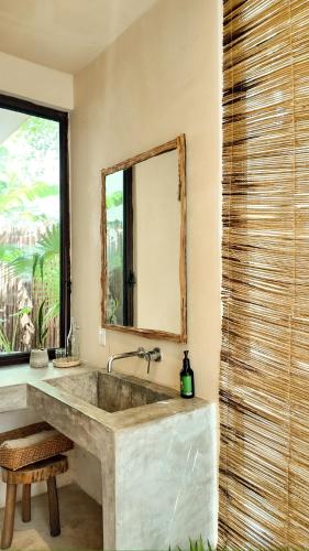 a bathroom with a large sink and a mirror at Ikal Bungalows Tulum in Tulum