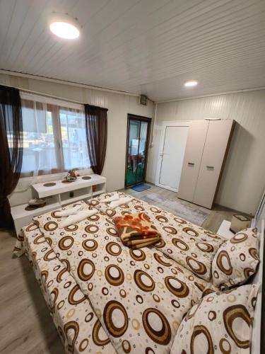 a bedroom with a large bed and a bathroom at Къща за гости Зеленец in Sozopol