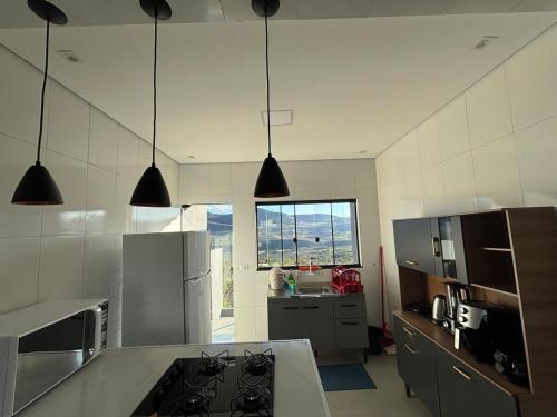 a kitchen with black lights hanging from the ceiling at Casa completa com wifi, garagem, próximo ao centro in Piatã