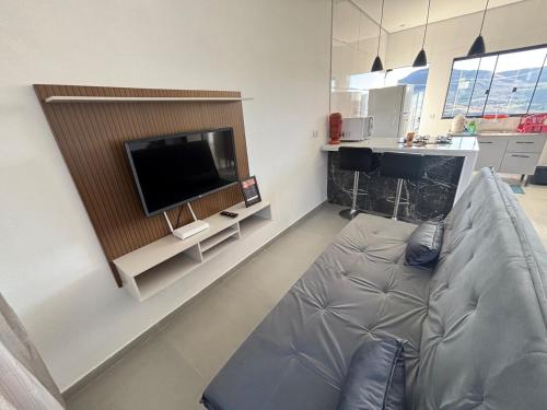 a living room with a couch and a flat screen tv at Casa completa com wifi, garagem, próximo ao centro in Piatã