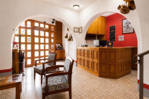 a kitchen with arches and a table and chairs at Hotel Posada el Cid in Oaxaca City