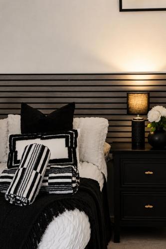 a bedroom with a bed with black and white pillows at Newcastle City Centre 2BR, Near Central Train Station in Newcastle upon Tyne