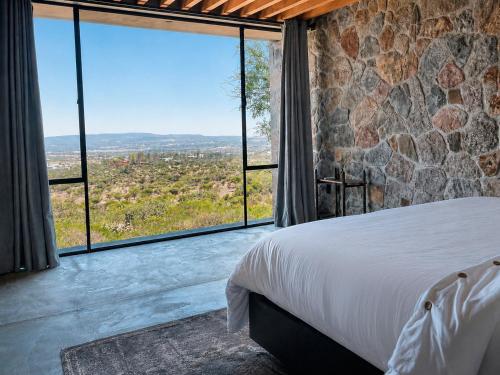 a bedroom with a bed and large glass windows at Casa X in San Miguel de Allende