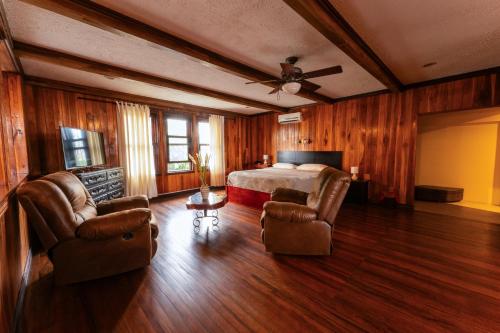 a bedroom with a bed and two chairs in it at Hotel Castillo in San José