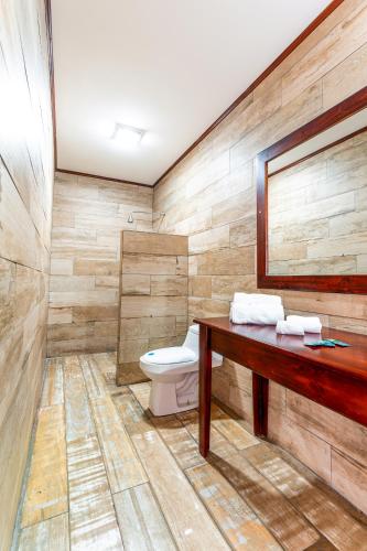 a bathroom with a toilet and a wooden counter at Hotel Castillo in San José