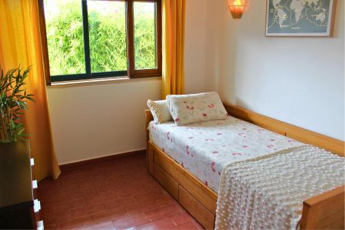 a small bedroom with a bed and a window at Casa do Castelo - Calm & lovely 2-bedroom Apt Near the Beach in Sesimbra