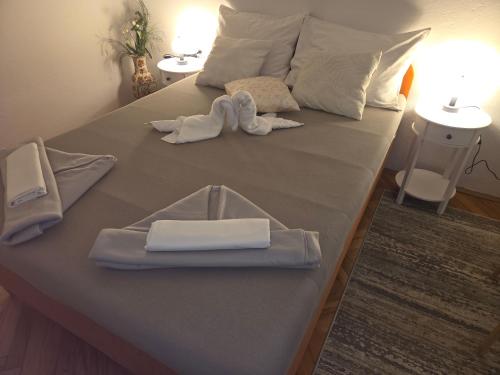 a bed with white towels and slippers on it at Casa Maja in Karlobag