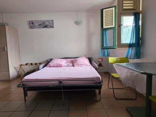 a bedroom with a bed with a pink pillow at SCI Severin in Pointe-à-Pitre
