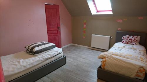 a bedroom with two beds and a red door at La Varendiere in Saint-Lambert