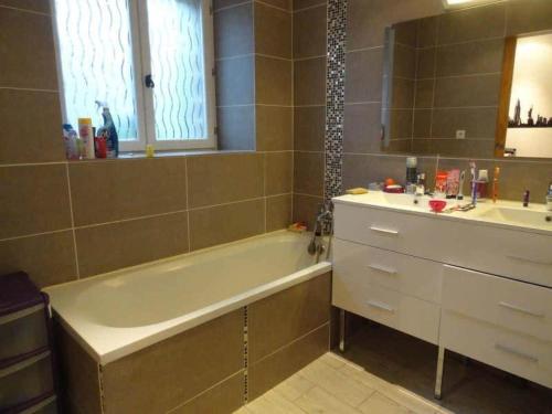 a bathroom with a bath tub and a sink at La Varendiere in Saint-Lambert