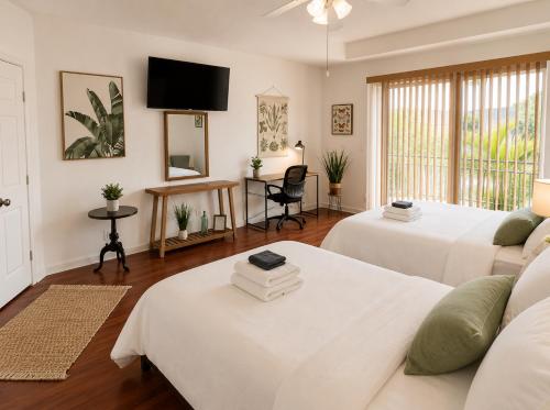 a living room with two beds and a tv at The Oasis, Miami Lakes in Miami Lakes
