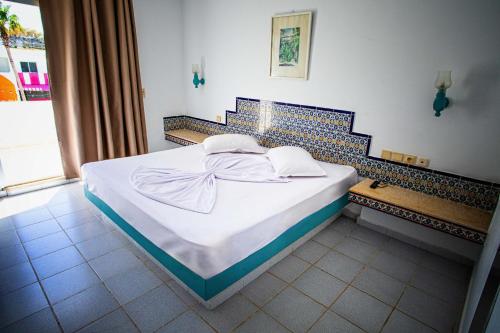 a bedroom with a white bed with a blue tiled wall at The Village Resort By Acquaviva Gammarth in Gammarth