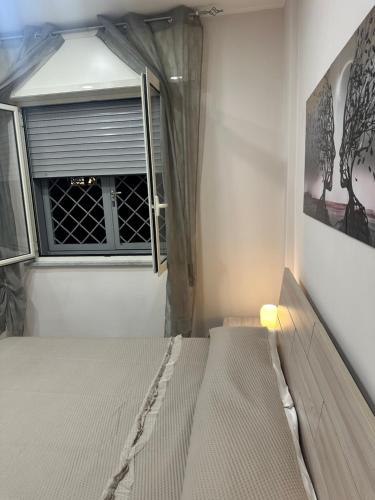 a bedroom with a bed and a window at Solforia Holiday House in Pozzuoli