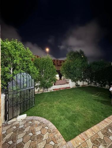 a backyard at night with a green lawn at الساحل الشمالي قرية الروضة in El Alamein