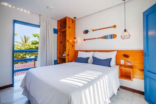 a bedroom with a white bed and a balcony at Vila Maria Pousada in Jericoacoara