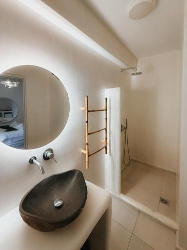 a bathroom with a black sink and a shower at Lumera Suites in Firostefani