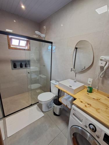 a bathroom with a shower and a toilet and a sink at Casa VNE 01 in Araranguá