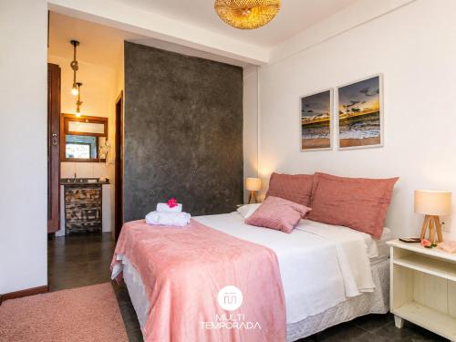 a bedroom with a bed with a pink blanket at Bollté Praia Boutique Pousada - Campeche - Floripa - SC in Florianópolis
