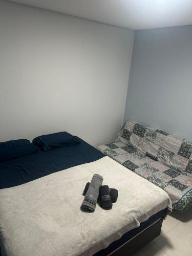 a bedroom with two beds with remotes on it at Casa completa bem equipada ótima localização in Joinville