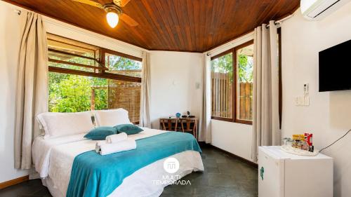 a bedroom with a bed and a large window at Bollté Praia Boutique Pousada - Campeche - Floripa - SC in Florianópolis