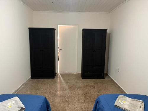 two black doors in an empty room with two beds at 9 De Julio in Charata