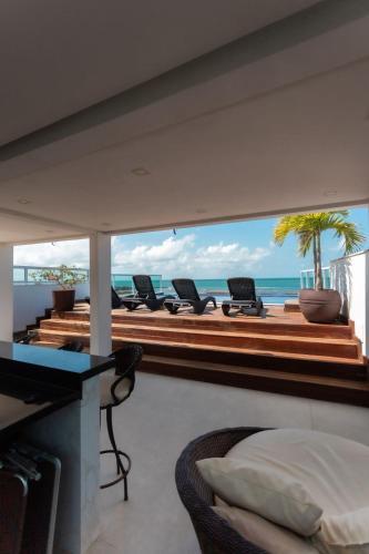a bedroom with a view of the ocean on a balcony at Pousada Pénareia in Morro de São Paulo