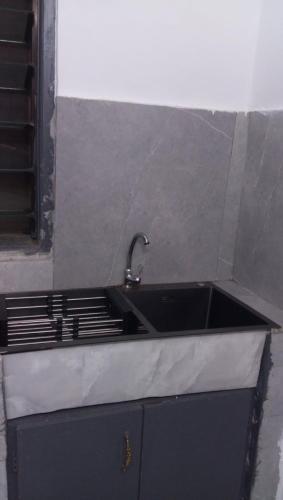 a kitchen sink with a faucet on top of it at Résidence cosy in Abidjan