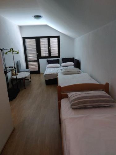 a room with three beds and a chair at Villa Valinor in Slatina Varoš