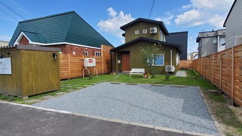 a backyard with a house and a fence at Biei Central Villa 2 - Olive House in Biei