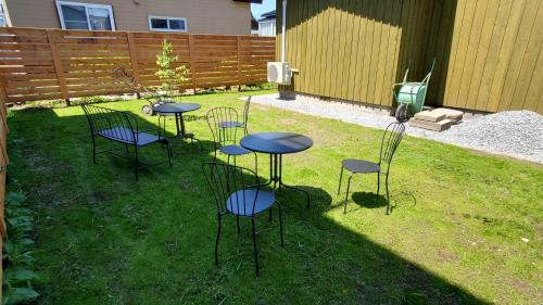 a group of tables and chairs in the grass at Biei Central Villa 2 - Olive House in Biei