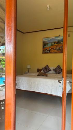 a bed in a room with a bed sidx sidx sidx at Santika Guest House in Ubud