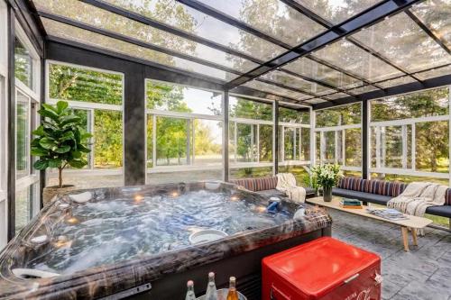 a large hot tub in a room with windows at Executive Acreage 3 King Beds Fireplace AC in Airdrie