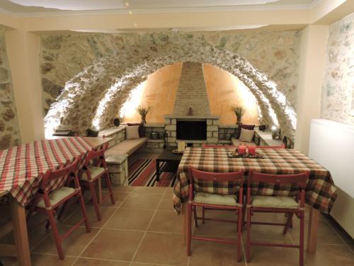 comedor con mesa, sillas y un arco en Gartagani Guest House, en Stemnitsa
