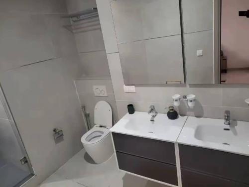 a bathroom with a toilet and a sink and a mirror at F3 ngor virage in Dakar